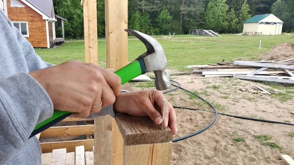 Avluda çivi çakan bir adam