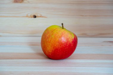 Ahşap masada kırmızı taze elma.