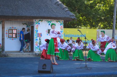 Velyki Sorochintsi, UKRAINE - 25 Ağustos 2017: Geleneksel giysiler içinde giyinmiş bir kadın Ukrayna 'nın ulusal pazarında cep telefonu ile fotoğraf çekiyor: 