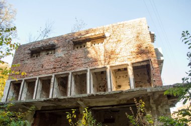 Güneşli bir günde, sonbahar ormanında terk edilmiş bir bina.