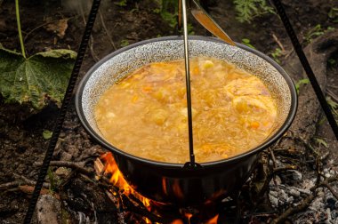 Açık havada kazanda geleneksel Macar gulaş çorbası pişirmek.