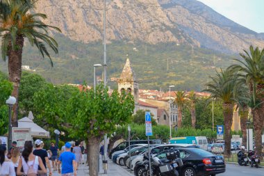 MAKARSKA, CROATIA - 11 Haziran 2019 'da Hırvatistan' ın Dalmaçya eyaletinin Makarska kentindeki iskelenin önündeki Makarska Gezinti Alanı. 