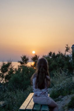 Adriyatik Denizi 'nde gün batımı, önünde bulanık bir çocukla, Makarska, Hırvatistan 
