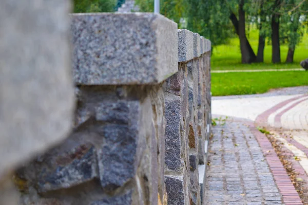 Stone fence on bridge at garden background