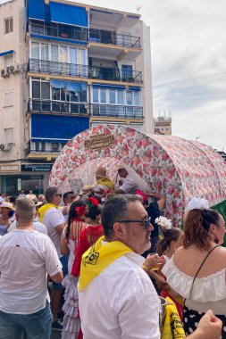 TORREMOLINOS, SPAIN - 21 Eylül 2025: İspanya 'nın Torremolinos kentindeki festivalden önceki Pazar günü geleneksel San Miguel haccını renkli arabalarla, müzikle ve Endülüs festivalinde giyilen insanlarla kutlamak.