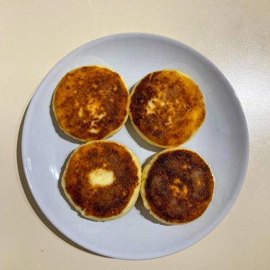 Geleneksel Ukrayna peynirli kekleri, syrnyky olarak bilinir, sıcak servis edilir