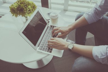 Kahve dükkanında dizüstü bilgisayar kullanan adam