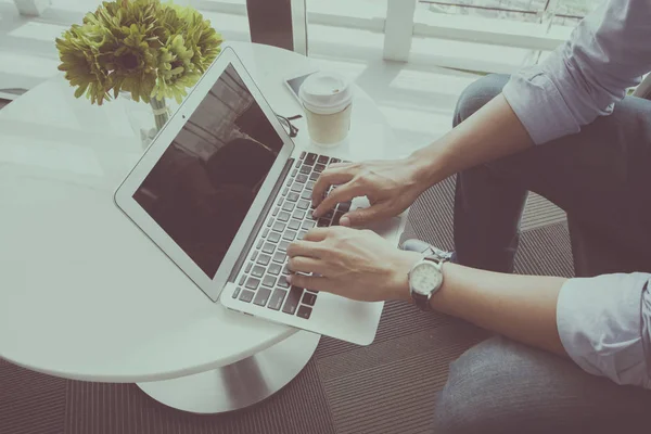 Kahve dükkanında dizüstü bilgisayar kullanan adam