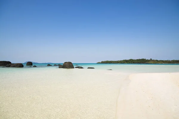 Piaszczysta plaża z krystalicznie czyste wody morskie i błękitne niebo. — Zdjęcie stockowe