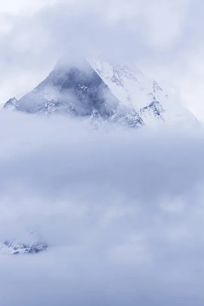 Montanha pico no Nepal. Montanha rochosa com neve na névoa — Fotografia de Stock