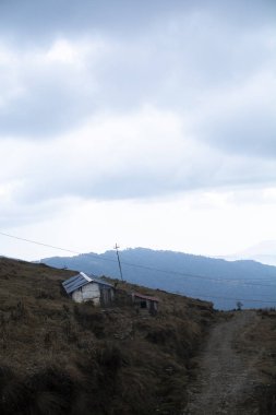 Bulutlar ile gökyüzüne karşı tepede küçük bir ev