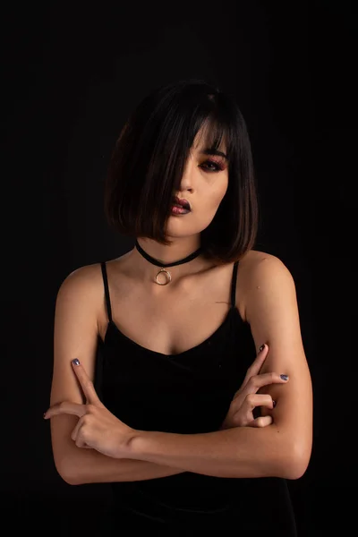 Southeast asian woman with dark tone makeup on black background,