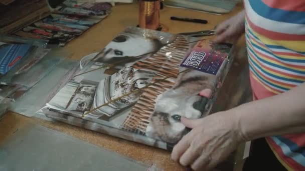 一个女包装商包装了一套有漂亮狗图案的床单 — 图库视频影像