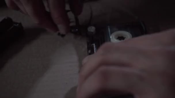 Un homme répare une cassette audio 