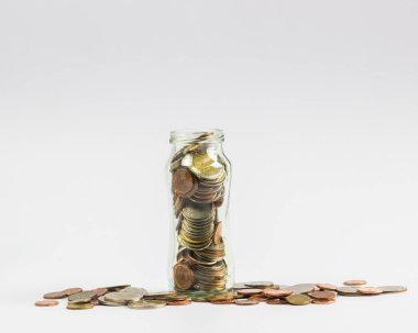 Tasarruf, yatırım artan para kavramı: tam bir beyaz arka plan üzerinde birçok bozuk para ile bir açık cam kavanozun içinde paralar.