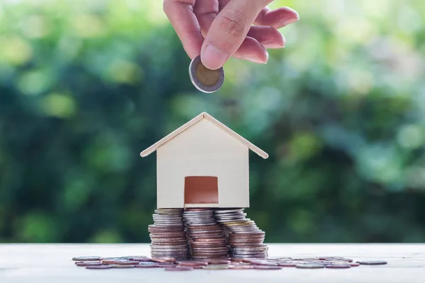 住房贷款 房地产投资为未来的概念 一个人手把硬币在小住宅房子上的堆栈硬币与绿色的自然背景 可持续投资 — 图库照片