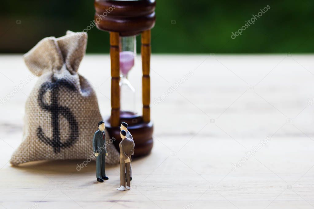 Financial investment negotiation,discussion among CEO or execute level concept: Miniature figurine three businessmen talk on money invest contract agreement, discuss about company direction in future.