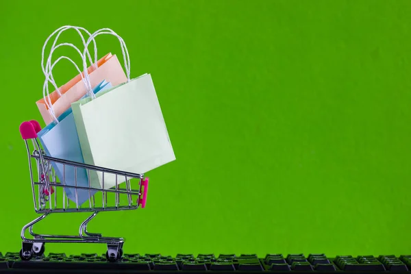 Online market place, eCommerce concept : Shopping cart with shopping bag ready to shop on black keyboard Ordered by customer through the media via internet show that trading is quick and easy.