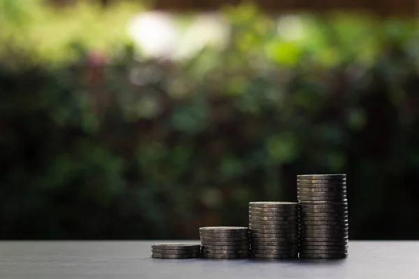 Växande staplade mynt på trä bord med grön natur som bakgrunds — Stockfoto