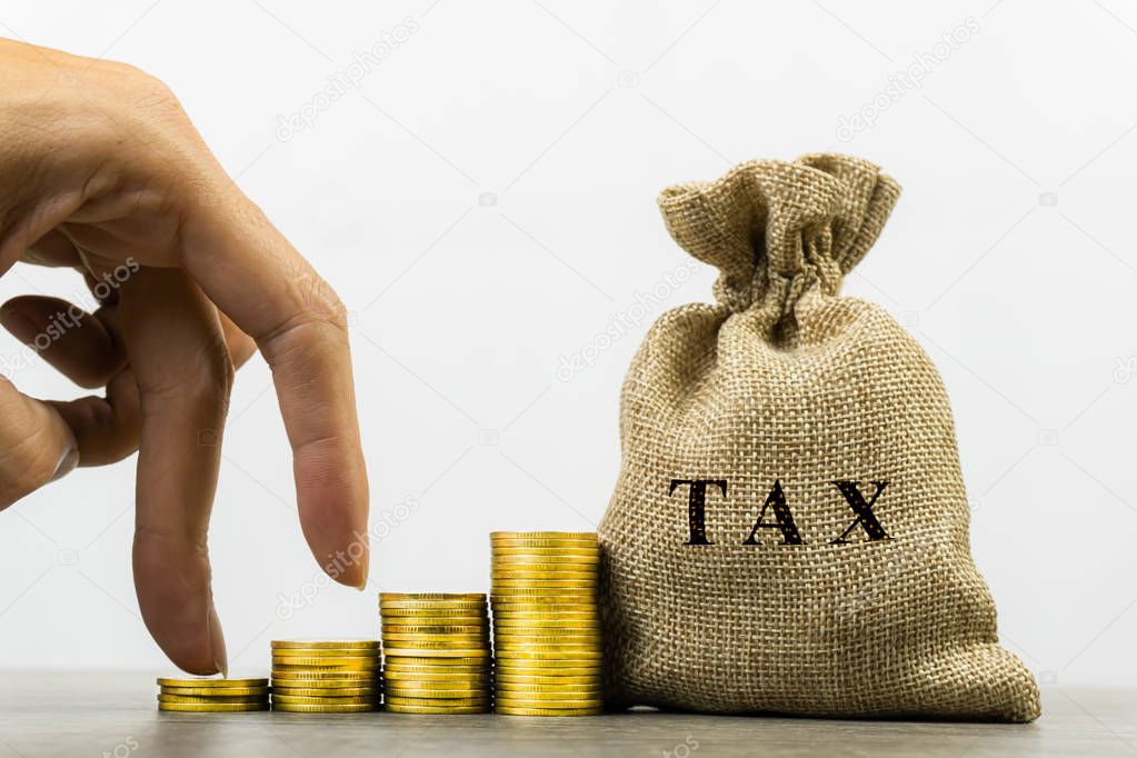 Taxation and Annual tax concept. A man hand on rising stack of c