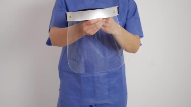 Εμφάνιση Διάφανης Πλαστικής Ασπίδας Προσώπου Χέρια Μπλε Ιατρική Στολή — Αρχείο Βίντεο