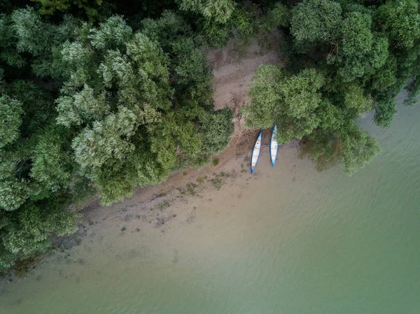 空中ビューの下の川の上の海岸に2つのカヌー ロイヤリティフリーのストック写真