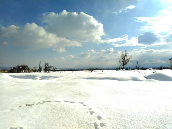 Ένα Πεδίο Χιονιού Κοντά Λαμπερό Γαλάζιο Ουρανό Σύννεφα Και Ήλιο — Φωτογραφία Αρχείου