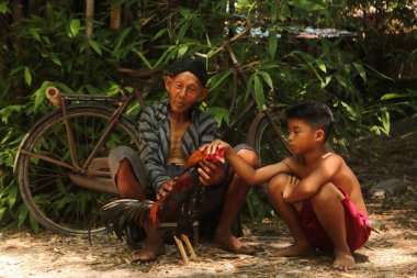 19 Ocak 2020, Bantul, Endonezya: Büyükbabalar ve torunlar gün boyunca horozlara bakıyorlar.