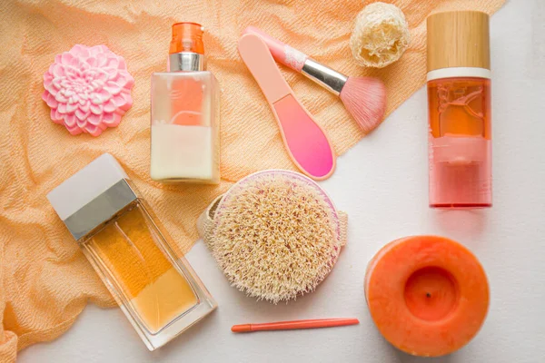 Flat lay composition with cosmetic products on pink background. Female self-care. Top view.