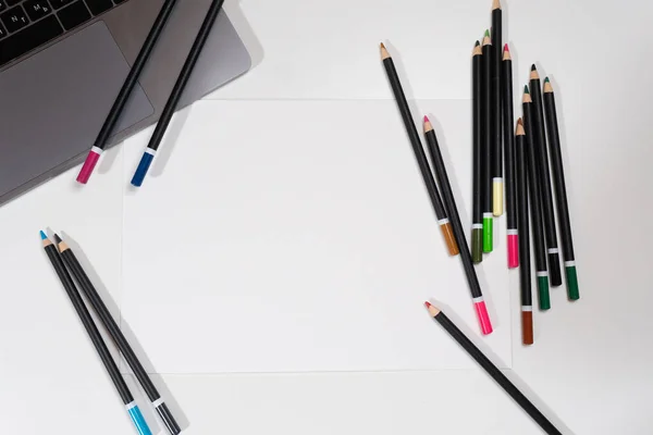 Papel en blanco sobre la mesa con portátil y lápices — Foto de Stock