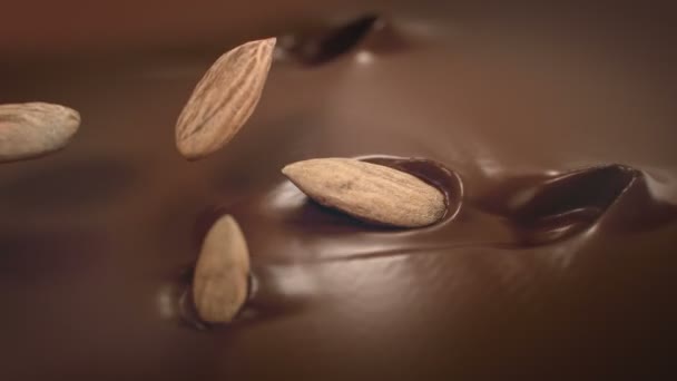 Mandlové oříšky cákat do tekuté čokolády v 4K Super zpomalený film