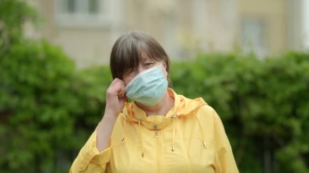 Mulher Contra Fundo Folhas Verdes Uma Casa Bege Remove Máscara — Vídeo de Stock