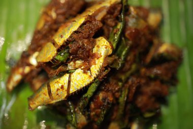 Mathi Pollichathu. Kerala usulü sardalya balığı hazırlama. Hint baharatlarıyla marine edilmiş balık ve muz yaprağına sarılmış ondan sonra sıcak tawa 'da hindistan cevizi yağıyla kızartılmış.