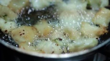 Sıcak yağlı soğan vada, yemek pişirme tavasına yakın görüntüde, Hint yemekleri geleneksel ev yapımı, bazı bölgelere ulli vada deniyor..