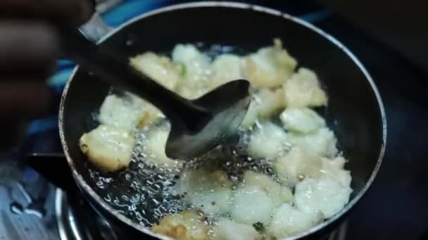 伝統的な家庭料理で作るインド料理 鍋のクローズアップビューで沸騰油とタマネギVada いくつかの地域これはUlli Vadaと呼ばれています — ストック動画