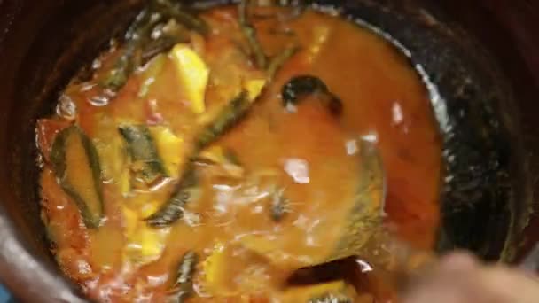 Meen Vattichathu or Pattichathu, sardine fish cooked. Traditional hot and spicy fish curry Kerala India with dried red chilly and green curry leafs. Very popular coastal food eat with tapioca or rice Meen Vattichathu Pattichathu Sardine Fish Cooked Traditional Hot Spicy Fish Stock Footage