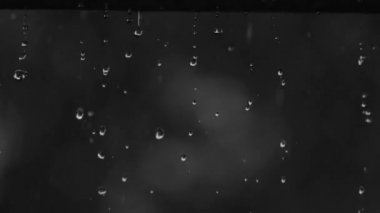 Yere düşen su damlası, doğa arka planda bokeh. Yağmur damlaları ve sıçramalar. Siyah arkaplan