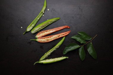 Kırmızı ve yeşil biber dilimlenmiş, tahta, siyah tahta üzerinde.. 