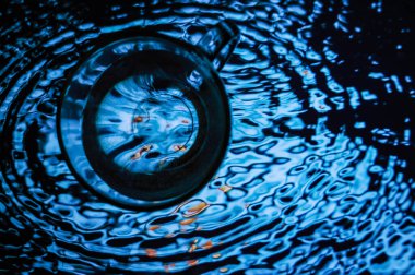 Bir bardak suyun üzerinde duruyor.