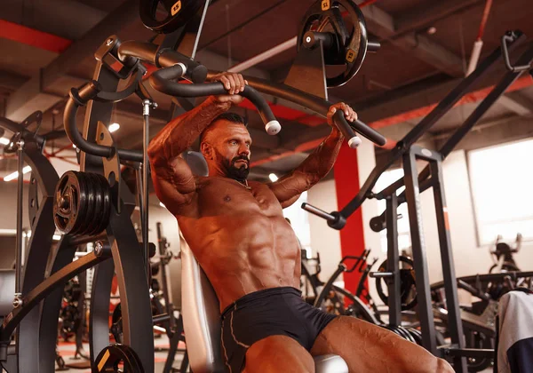 Göğüs basın. Egzersizleri yapıyor spor salonunda yakışıklı kaslı seksi adam. Tabaklanmış atlet. Göğüs egzersiz programı.
