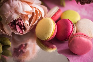 Pembe bir arka plan üzerinde kek kurabiye. Üstten görünüm macaron tatlı kapatın. Pastel pembe, sarı renkler renkli badem çerezler. Vintage tarzı tonlama.