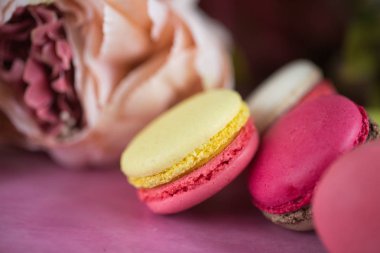 Pembe bir arka plan üzerinde kek kurabiye. Üstten görünüm macaron tatlı kapatın. Pastel pembe, sarı renkler renkli badem çerezler. Vintage tarzı tonlama.