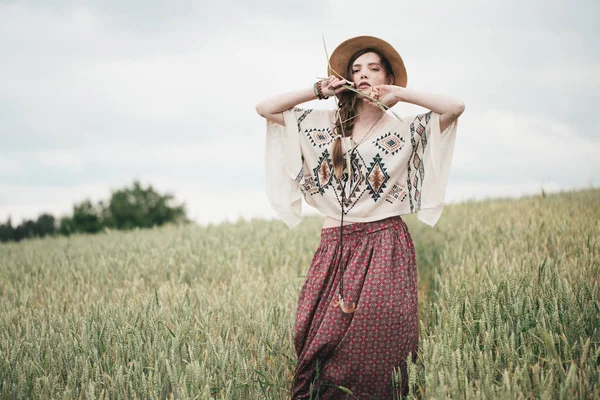 Doğa arka planda poz Eko Stil giysili kızı. Boho şapkalı genç kadın portresi. Güzel etno yabancı alanındaki.