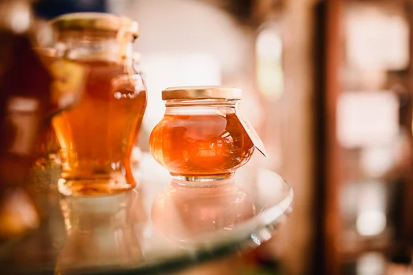 stock image Close up food image of natural honey in little jar on shell on the market. Sunny warm trend toning photo,