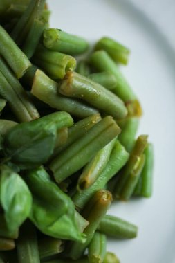 Sağlıklı gıda kavramı. Beyaz tabakta Fesleğenli haşlanmış kuşkonmaz. Görünümü kapatın.