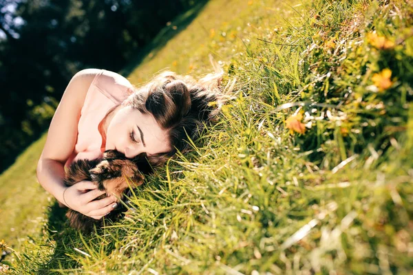 고양이 함께 잔디에 누워 소녀입니다. 봄 또는 여름 따뜻한 날씨 개념. Bokeh 배경입니다. 진저 고양이 두 얼굴 색상 마스크 — 스톡 사진