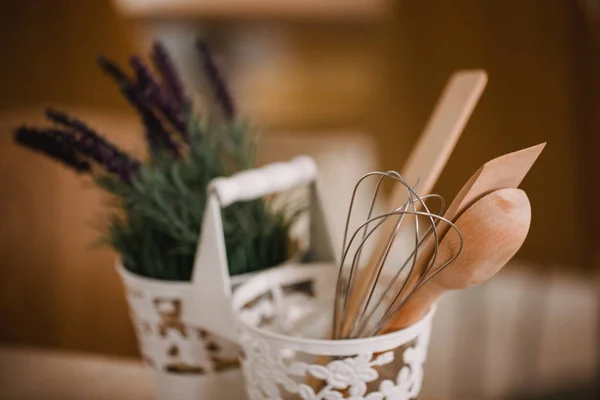 Kitchen accessories in the style of Provence. Devices for cooking from natural wood. Lavender in a pot. Background for food concept design or interior design.