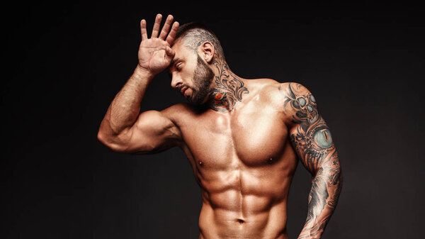Banner image of sexy man with muscular body. Portrait of sexi male model. Hot macho, bodybuilder with muscle torso in abs poses on black background. 16 in 9 crop for design