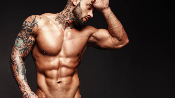 Banner image of sexy man with muscular body. Portrait of sexi male model. Hot macho, bodybuilder with muscle torso in abs poses on black background. 16 in 9 crop for design