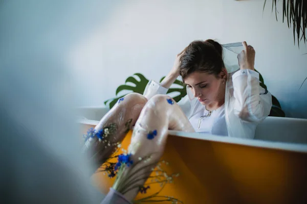 Retrato de moda da menina em roupas de tendência de plástico. Eco styling. Modelo deitado no banho — Fotografia de Stock